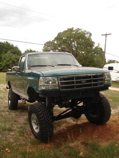 1996 Ford F-150 - This lifted 1996 Ford F-150 pickup truck is shown from the front in a rural setting.
