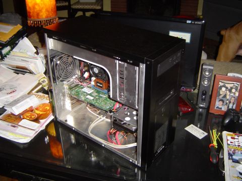 1989 Ford Bronco - An open computer case reveals its internal components, including the motherboard and graphics card, on a cluttered desk.