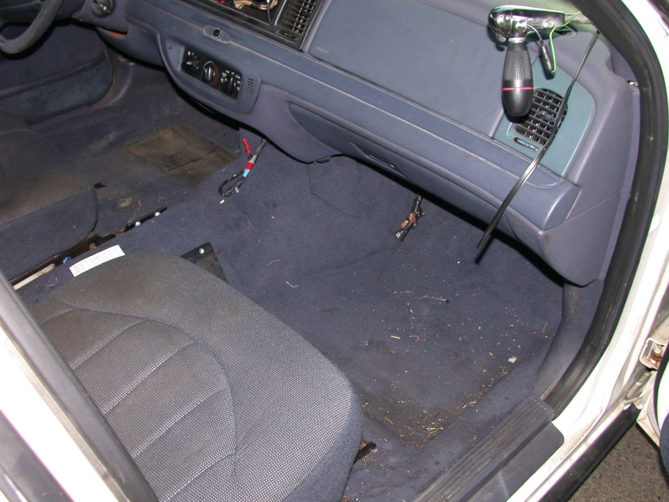 Interior of a 2000 Ford Crown Victoria showing the driver's side seat, dashboard, and floor