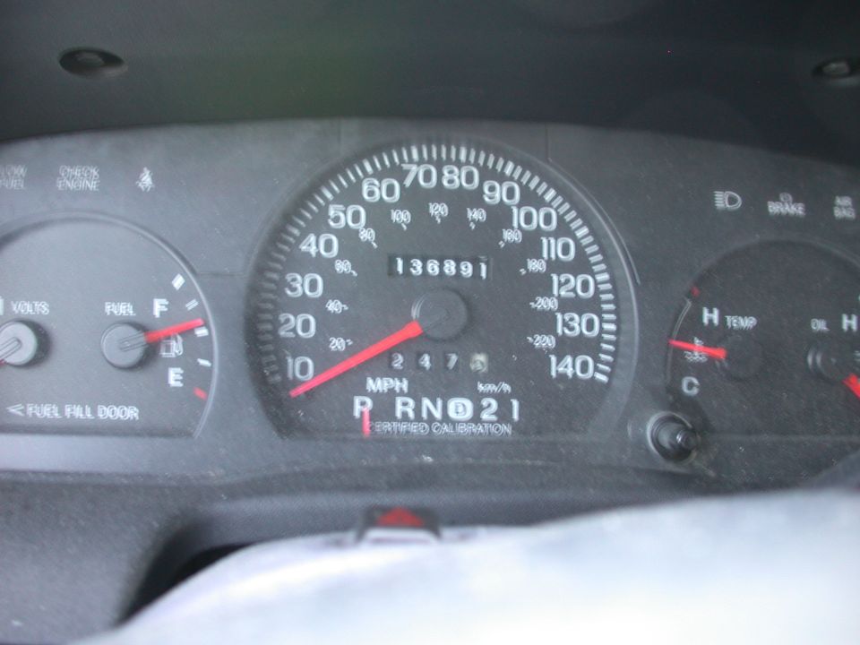 Car dashboard with speedometer, odometer showing 136891 miles, fuel gauge, and temperature gauge
