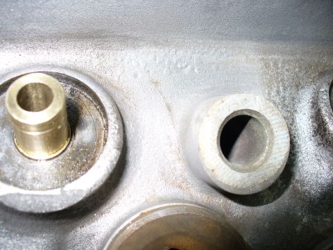 1971 Toyota Corolla - Close-up view of an engine cylinder head, showing a brass valve guide and a machined opening for a valve seat.