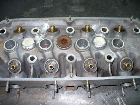 1971 Toyota Corolla - This engine part shows multiple valve openings and brass fittings, with some sealant visible.