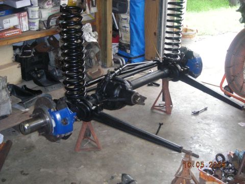 1993 Ford Bronco - Vehicle axles and suspension components are displayed in a workshop setting.