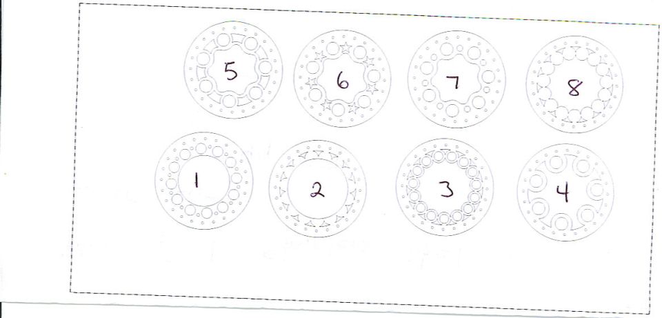 Faint line drawing of eight numbered wheel or rim designs in a grid