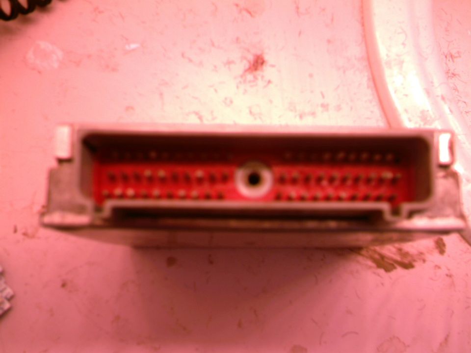 ECM connector with red pins and a central hole, grey casing