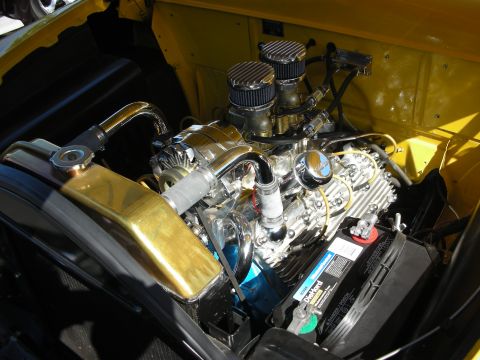 1998 Ford Crown Victoria - Close-up of a polished engine bay chrome components and a brass radiator, likely from a classic car.