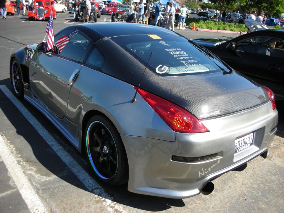 Silver Nissan 350Z with carbon fiber hood and aftermarket wheels, parked at a car show