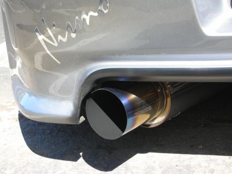 1998 Ford Crown Victoria - Close-up of a vehicle's rear bumper a Nismo decal and a colorful, aftermarket exhaust tip.