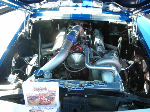 1998 Ford Crown Victoria - Customized engine bay with prominent turbochargers and intercooler, displayed at a car show.