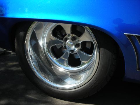1998 Ford Crown Victoria - Close-up of a shiny chrome wheel on a custom blue vehicle.