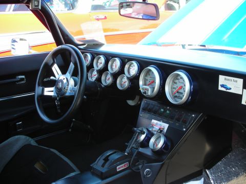 1998 Ford Crown Victoria - Interior view of a heavily modified car with a custom dashboard filled with gauges and switches.