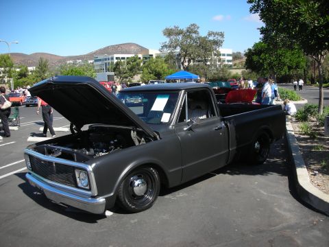 1998 Ford Crown Victoria - A classic pickup truck is displayed with its hood open at an outdoor event.