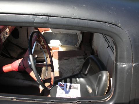 1998 Ford Crown Victoria - Interior of a car with a steering wheel and seat visible, showing some wear and tear.