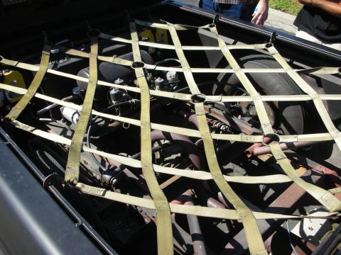 1998 Ford Crown Victoria - The engine bay is secured with a cargo net, revealing various mechanical components and a spare tire.