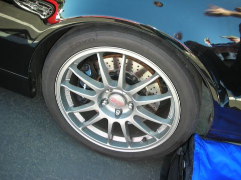 1998 Ford Crown Victoria - Aftermarket wheel and tire assembly with performance brakes on a black vehicle.