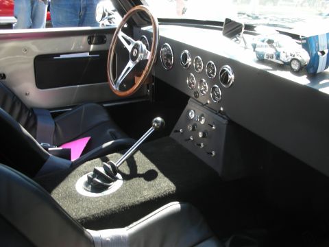 1998 Ford Crown Victoria - The dashboard of a classic car features numerous gauges and a prominent manual transmission shifter.
