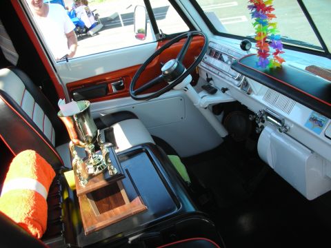 1998 Ford Crown Victoria - The interior of a van shows a trophy, an orange towel, and a lei hanging from the dashboard.