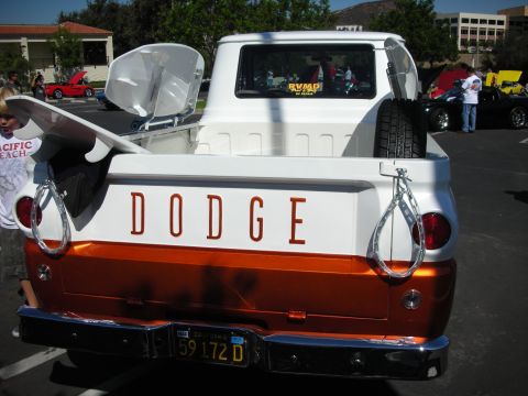 1998 Ford Crown Victoria - A classic Dodge pickup truck is displayed at a car show, a surfboard and spare tire in its bed.