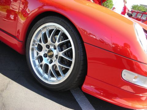 1998 Ford Crown Victoria - A close-up shot focuses on the intricate design of the BBS rims on a red sports car.
