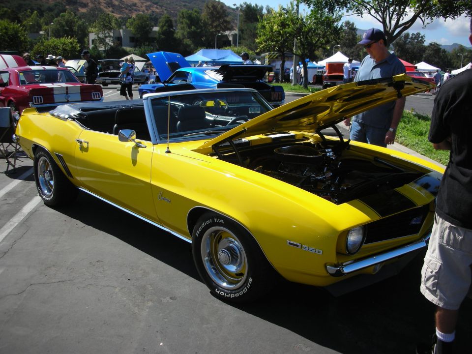 Yellow 1969 Camaro convertible with hood open, showing a 350 badge