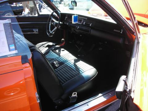 1998 Ford Crown Victoria - The interior of a classic muscle car is shown, quilted black seats and a dashboard with a blue air freshener.