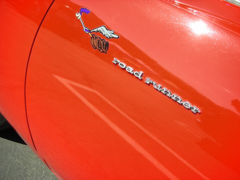 1998 Ford Crown Victoria - Close-up of a red car fender displaying the iconic Road Runner emblem and the 'road runner' script.