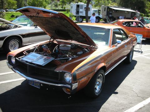 1998 Ford Crown Victoria - AMC Javelin AMX at a car show, hood open to display the engine bay.