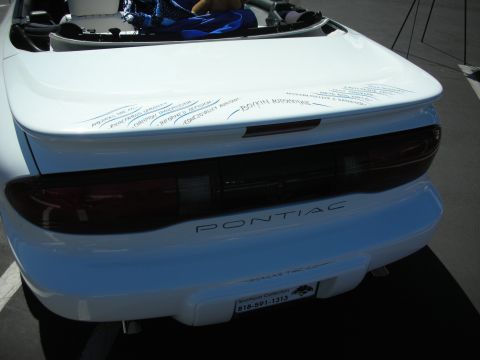 1998 Ford Crown Victoria - Rear view of a white Pontiac Firebird, showing the taillights and 'PONTIAC' branding.