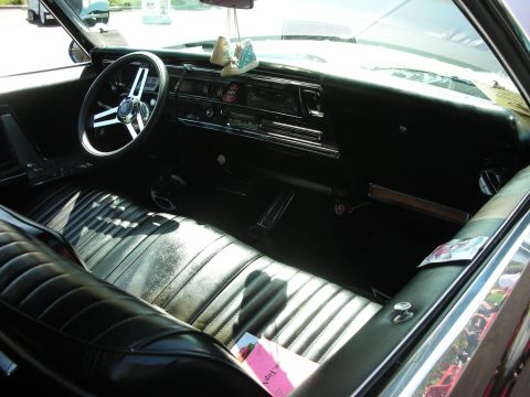 1998 Ford Crown Victoria - The interior of a vintage car features ribbed vinyl seats and a classic dashboard with a retro radio.