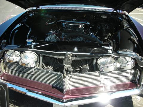 1998 Ford Crown Victoria - Classic car engine bay a prominent chrome grille and dual headlights.