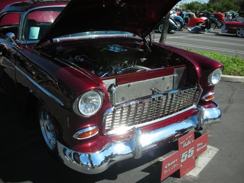 1998 Ford Crown Victoria - A classic maroon 1955 Chevrolet Bel Air is displayed with its hood open at a car show.