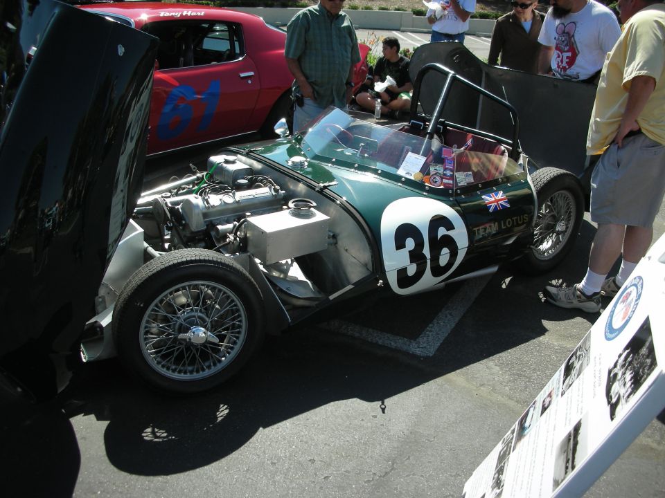 Green race car with number 36, Union Jack, and 'TEAM LOTUS' text, hood open showing engine