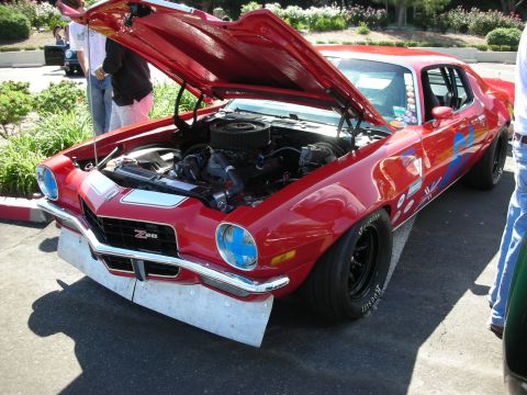 1998 Ford Crown Victoria - A red 1970 Chevrolet Camaro Z28 is displayed with its hood open, revealing the engine bay.