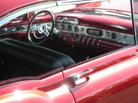 1998 Ford Crown Victoria - The interior of a red car shows black seats and a dashboard with chrome details.