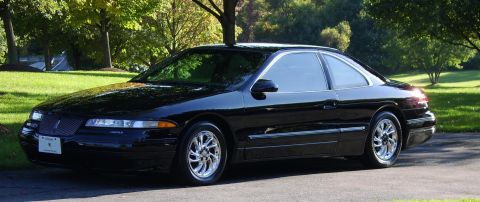1996 Mercury Grand Marquis - Black Lincoln Mark VIII coupe parked on a paved surface with trees and lawn visible.