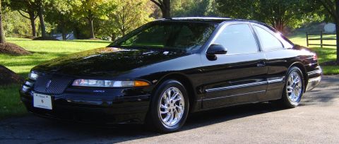 1996 Mercury Grand Marquis - A black Lincoln coupe is parked outdoors on a sunny day, with trees and a lawn visible.