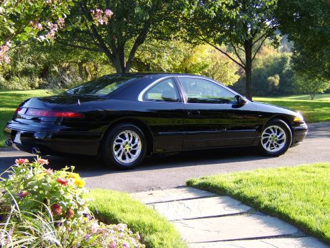 1996 Mercury Grand Marquis - A black 1996 Mercury Cougar XR7 is parked on a driveway during the day.