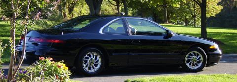 1996 Mercury Grand Marquis - Black coupe with chrome wheels and chrome trim around windows parked on asphalt.