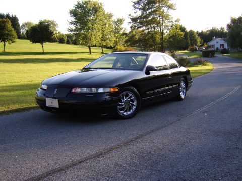 1996 Mercury Grand Marquis - A black Lincoln Mark VIII coupe is parked on a road in a rural setting during the day.