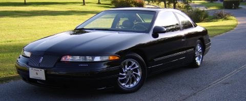 1996 Mercury Grand Marquis - This black coupe features chrome wheels and is parked on a residential street.