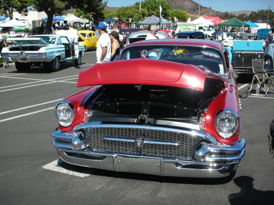 Red classic car front view, hood open. Appears to be a 1950s model