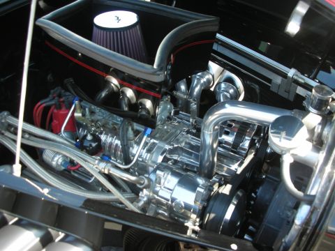 1998 Ford Crown Victoria - Close-up view of a highly customized engine bay a polished supercharger and a prominent air intake system.