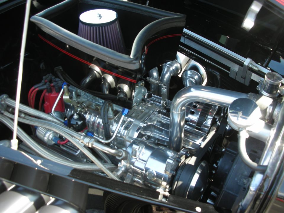 Engine bay with chrome supercharger, air intake, and red distributor cap