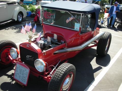 1998 Ford Crown Victoria - This vintage Ford hot rod, likely from the 1920s, is displayed with patriotic flair at a car show.