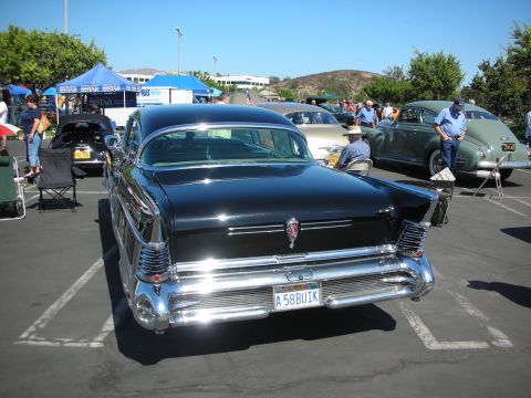 1998 Ford Crown Victoria - A classic black Buick is displayed at an outdoor car show with other vintage vehicles.