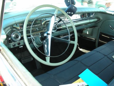 1998 Ford Crown Victoria - The interior of a classic car features a large steering wheel, dashboard, and upholstered seats.