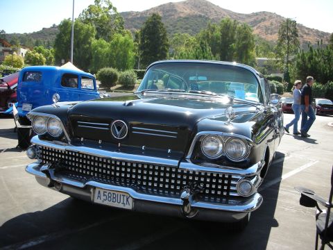 1998 Ford Crown Victoria - Front view of a classic 1958 Buick at a car show, with a blue vehicle behind it.