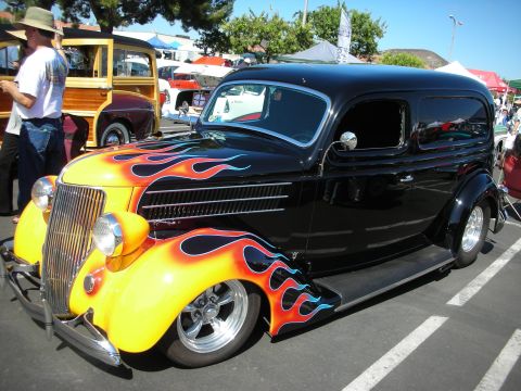 1998 Ford Crown Victoria - Custom hot rod sedan with flame paint job seen at a car show.