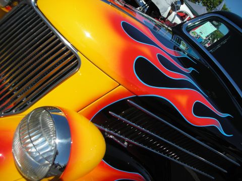 1998 Ford Crown Victoria - Close-up of a custom hot rod flame paint and chrome details at a car show.