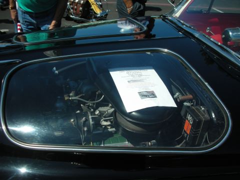 1998 Ford Crown Victoria - A document is placed on the engine of a black car, visible through a glass panel.